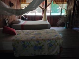 a bedroom with two beds and a window at Amazon Lodge Iquitos in Iquitos