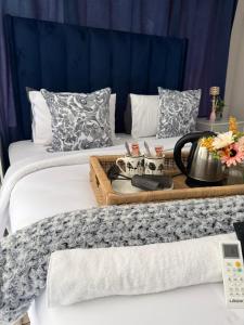 a hotel room with two beds with a tray of food at La Bushka Guesthouse in Bela-Bela
