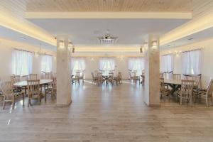 a large banquet hall with tables and chairs at Kaimo turizmo sodyba "Ąžuola" in Vainutas