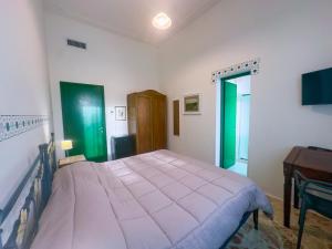 a bedroom with a large bed and a desk at Affitta camere ALMA MATER in Castrignano del Capo