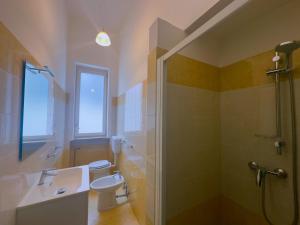 a bathroom with a toilet and a sink and a shower at Affitta camere ALMA MATER in Castrignano del Capo