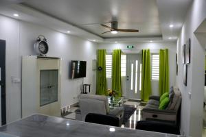 a living room with green curtains and chairs at Grapes of Grace in Baie Nettle