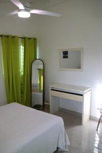 a bedroom with a bed and a dressing table and a mirror at Grapes of Grace in Baie Nettle