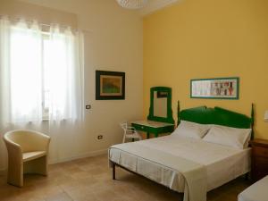 a bedroom with a bed and a desk and a mirror at Affitta camere ALMA MATER in Castrignano del Capo