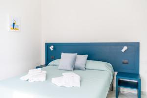a blue bed with white pillows and a blue headboard at Affittacamere 2 Prima Fila Mare in Porto Recanati