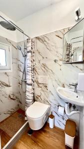 a bathroom with a toilet and a sink at Elina's Rooms in Poros