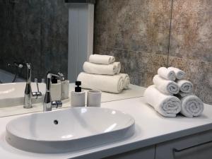 a bathroom with a sink and a pile of towels at Sunset Terrace Wrocław Stadion in Wrocław +13 photos