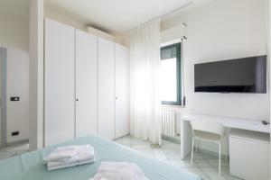 a white bedroom with a desk and a tv at Affittacamere 2 Prima Fila Mare in Porto Recanati