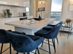 a kitchen with a island with four blue chairs at Sunset Terrace Wrocław Stadion in Wrocław