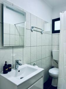 a white bathroom with a sink and a toilet at Seaside & Levada Escape in Machico +16 photos