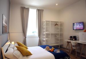 a bedroom with a bed and a desk and a window at Fortuna Guest House - Charm & Relax rooms in Syracuse