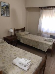 a room with two beds and a table and a window at Hotel JR in Mar del Tuyú