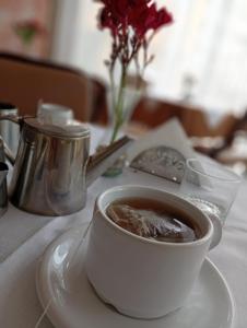 a cup of coffee on a white plate on a table at Hotel JR in Mar del Tuyú