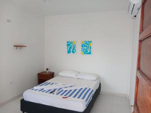 a small bedroom with a bed and a picture on the wall at AMAREA Hotel Boutique in Tolú +17 photos