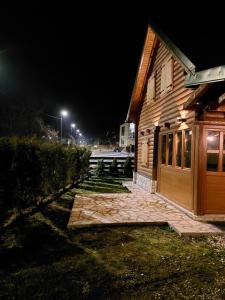 a wooden house with a bench next to it at night at Zara Chalet in Kolašin