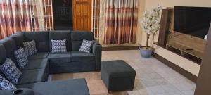 a living room with a couch and a tv at Pascall's Luxury Homes Villa in Lambeau