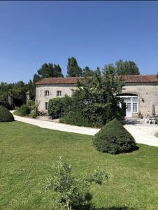 a large house with a grass yard in front of it at Le Pistoulet Gîte in Doeuil-sur-le-Mignon +24 photos