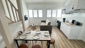 a small living room with a table and a kitchen at Les Myosotis in Vernon