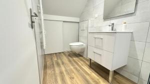 a white bathroom with a toilet and a sink at Les Myosotis in Vernon +18 photos