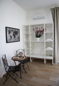 a room with a table and chairs and shelves at Fortuna Guest House - Charm & Relax rooms in Syracuse