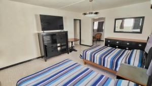 a bedroom with a bed and a dresser and a table at Hotel Catalina in Torreón