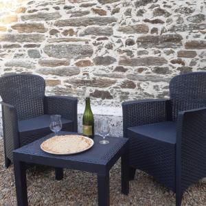 two chairs and a table with a bottle of wine at Les gîtes de Tréguennec in Tréguennec