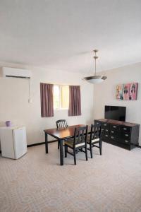 a living room with a table and chairs and a refrigerator at Hotel Catalina in Torreón