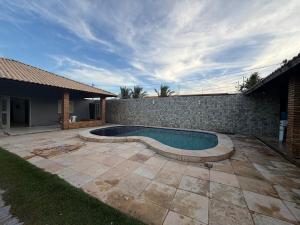 a swimming pool in a yard next to a house at Paracas House in Paracuru