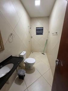 a bathroom with a toilet and a sink at Paracas House in Paracuru +14 photos