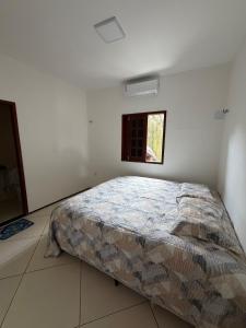 a bed in a white room with a window at Paracas House in Paracuru