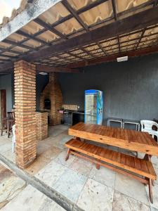 a wooden bench sitting on a patio with a table at Paracas House in Paracuru