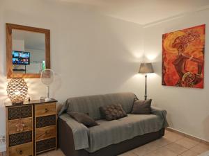 a living room with a couch and a mirror at Enjoy Studio in Pointe-Noire