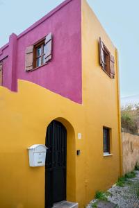 a brightly colored building with a door and windows at Old Town Nest in Rhodes Town
