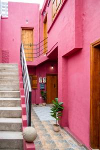 a pink building with stairs in front of it at Old Town Nest in Rhodes Town