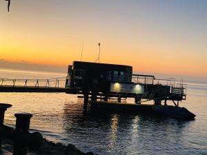 a house on a dock in the water at sunset at Lagoon Staycation in Walvis Bay