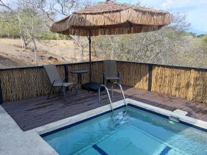 a deck with a table and chairs and an umbrella at Fruta de mango #2 in Lagunillas