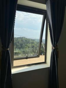 a window in a room with a view of a field at Trâm Anh Hotel in Kon Von Kla +14 photos