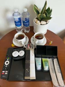 a table with a remote control and two cups of coffee at Trâm Anh Hotel in Kon Von Kla