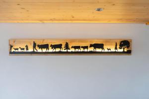 a wooden picture of cows and people on a wall at Ferienhaus Hörli in Sankt Peterzell