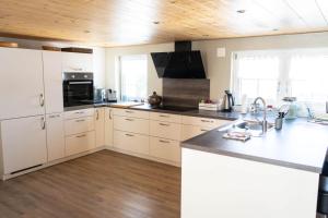 a kitchen with white cabinets and a wooden ceiling at Ferienhaus Hörli in Sankt Peterzell