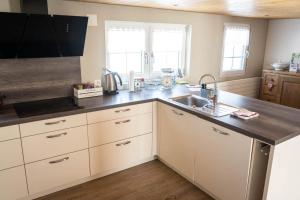 a kitchen with white cabinets and a sink at Ferienhaus Hörli in Sankt Peterzell