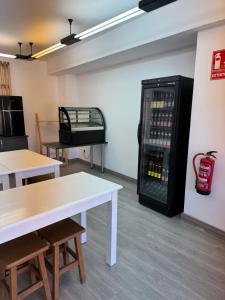 a room with tables and a soda vending machine at Albergue el cristo in Porriño +12 photos