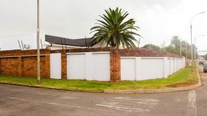 a brick building with two white garage doors at Phela Guesthouse in Edenvale