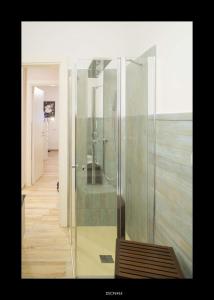 a glass shower in a bathroom with a wooden floor at Casa Porta D'Amalfi vicino Stazione e terminal Sita Salerno in Salerno +16 photos