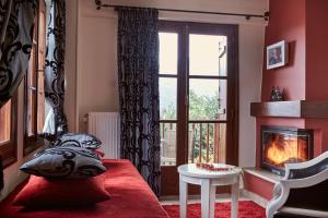 sala de estar con chimenea y sofá rojo en Hotel Dryades and Spa, en Agios Lavredios 82 fotos más