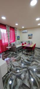 a living room with a table and a couch at Stylish Rose Garden Apartment with Balcony & Parking in Asenovgrad