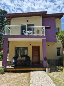 a house with a balcony with a table at Lihuen in Mar Azul