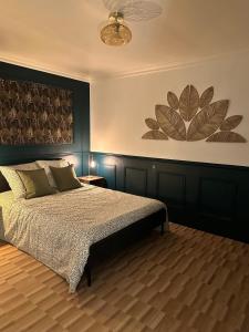 a bedroom with a bed and a painting on the wall at Escapade Chic in Renwez