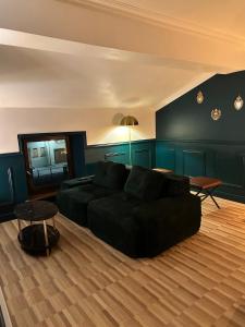 a living room with a black couch and a table at Escapade Chic in Renwez