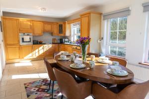 a kitchen with a wooden table with chairs and a dining room at Wild Atlantic Hideaway in Doolin